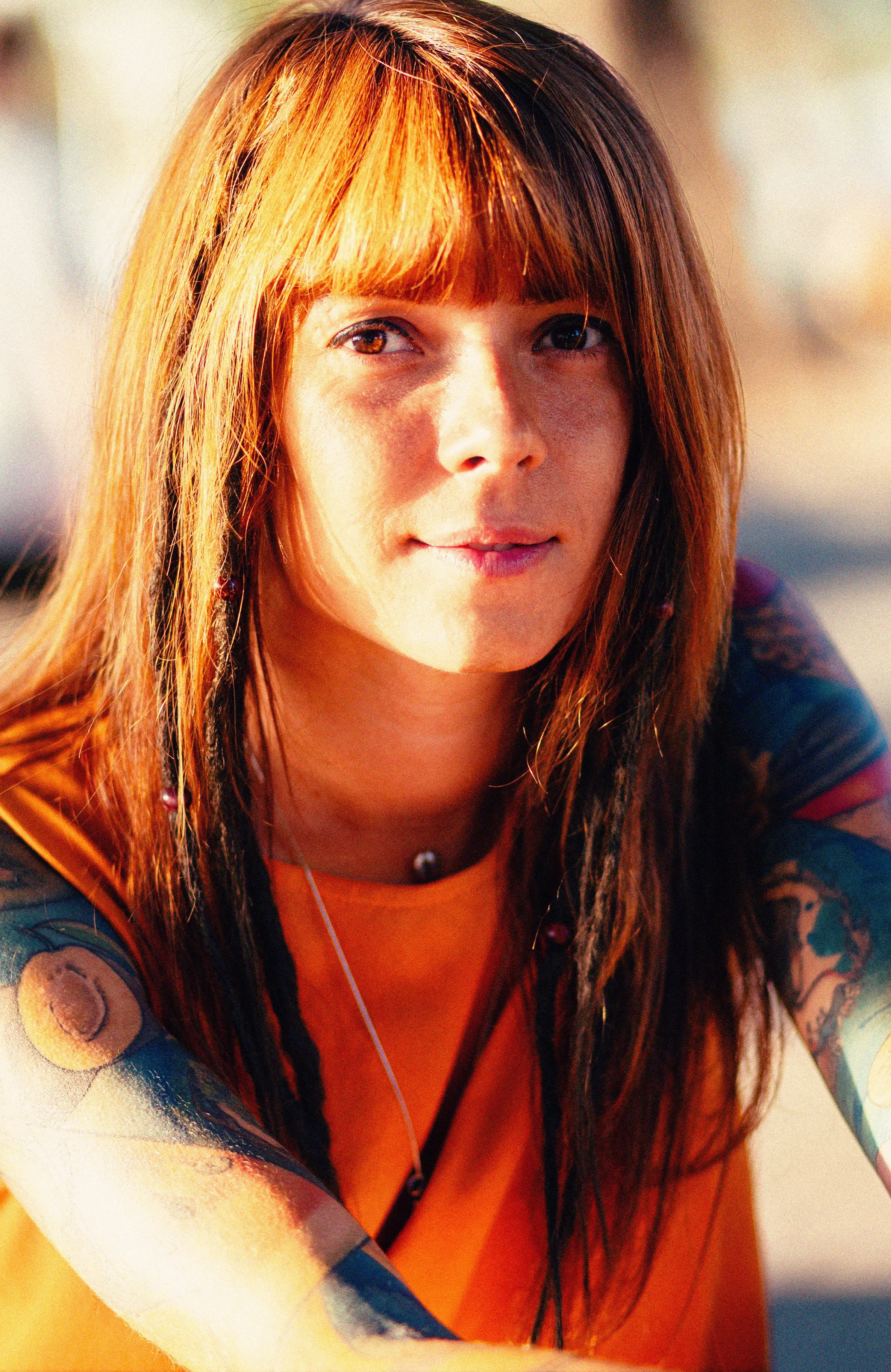 A young woman with red hair leans forward to listen to what you are saying